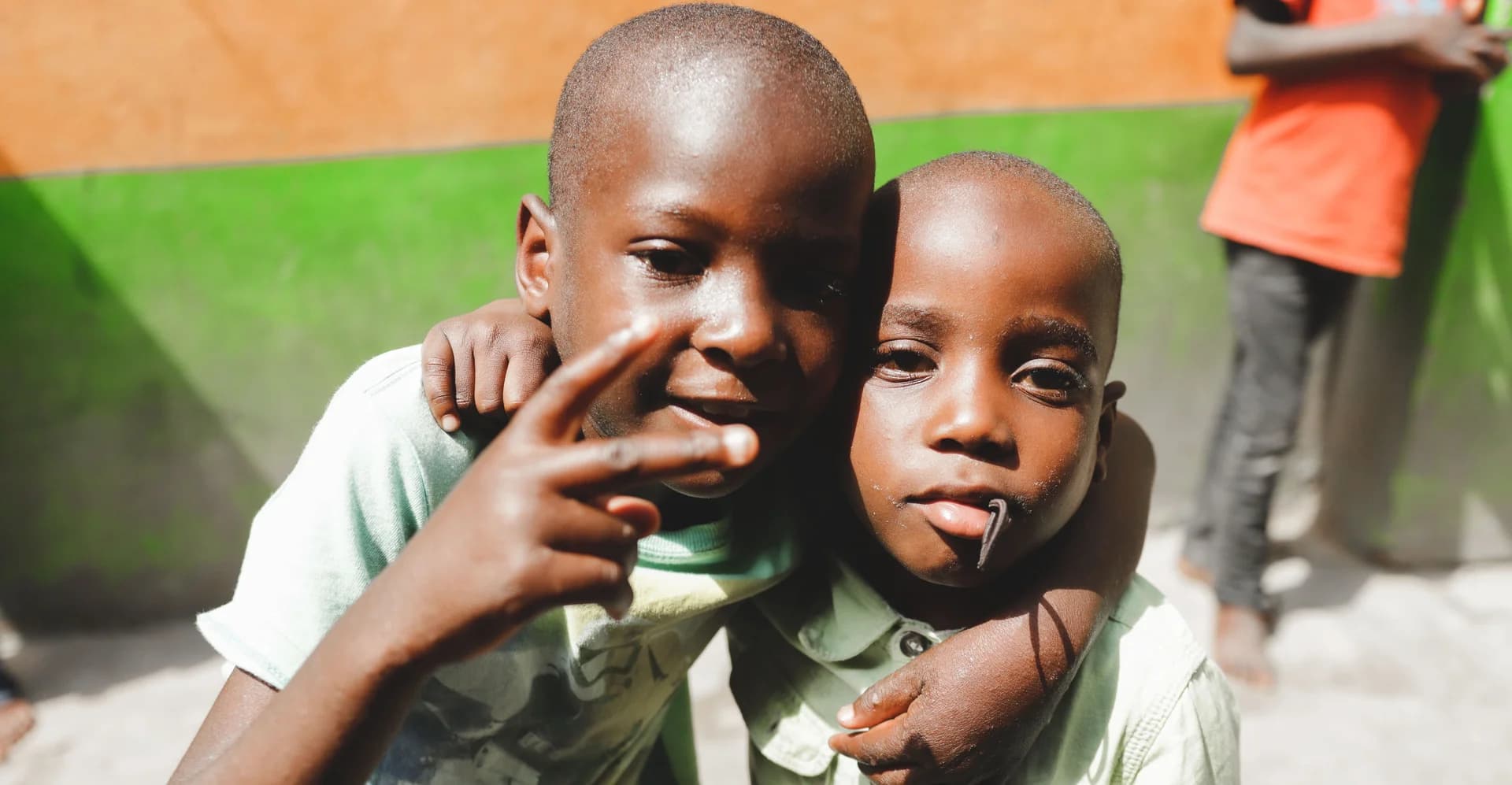 Two children standing together and looking towards the camera
